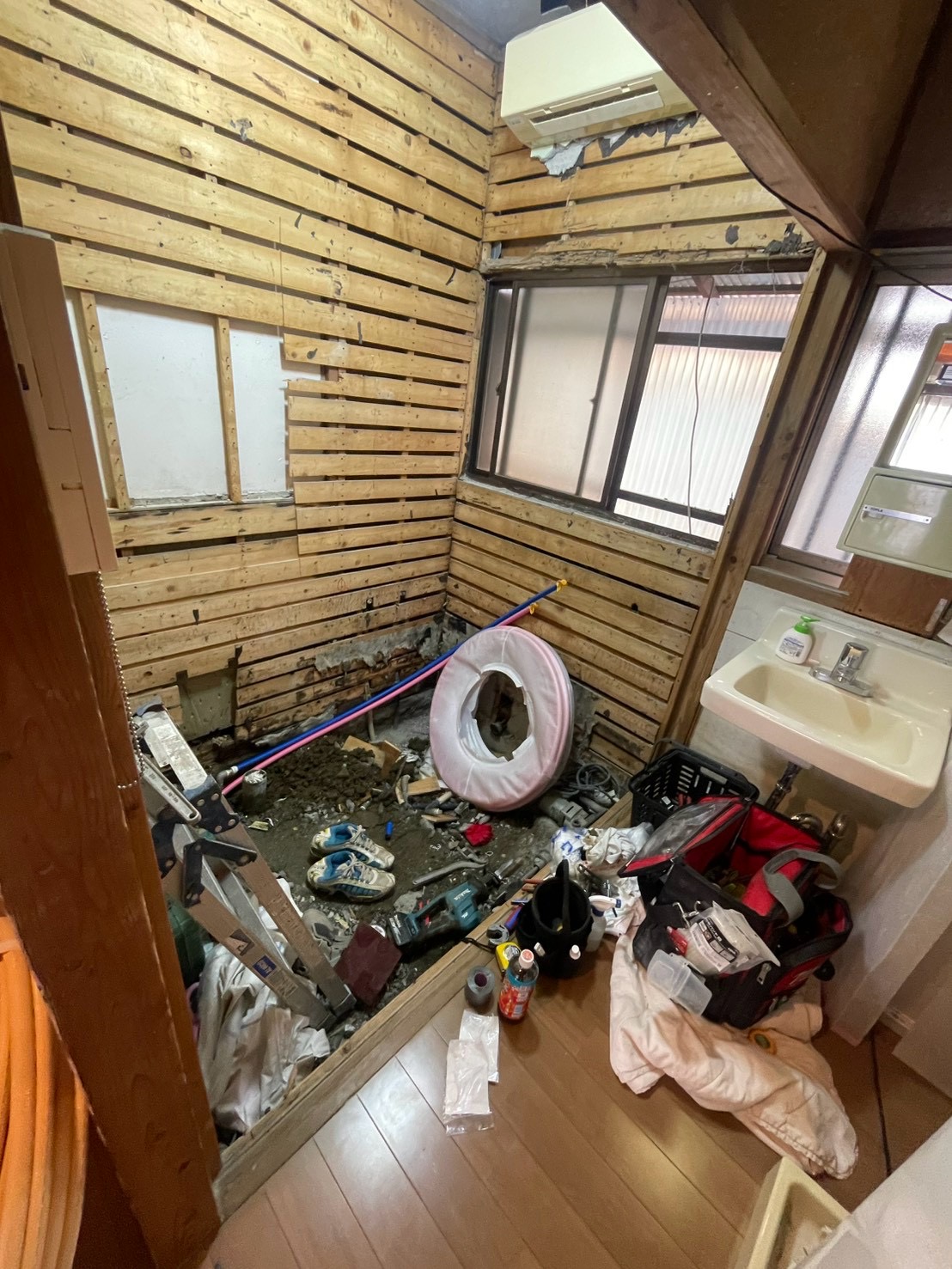 既存のタイル浴室を解体し、給水・給湯配管を施工している様子